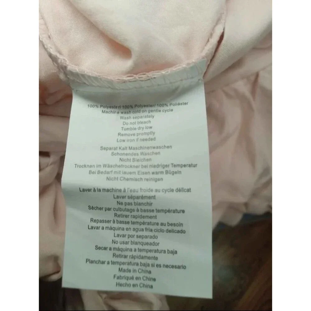 Light pink twin duvet cover with pillow sham. Ruffled edges and button close